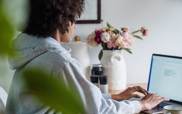 A woman working remotely at a desk with breakfast and coffee, showcasing a cozy home office setting. Une femme travaillant à distance à un bureau avec petit-déjeuner et café, mettant en avant un cadre de bureau à domicile confortable.