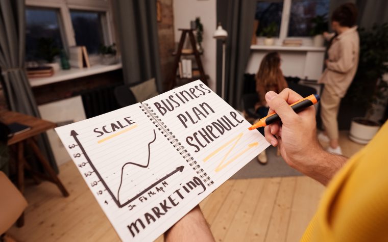 Personne notant stratégie business avec graphiques