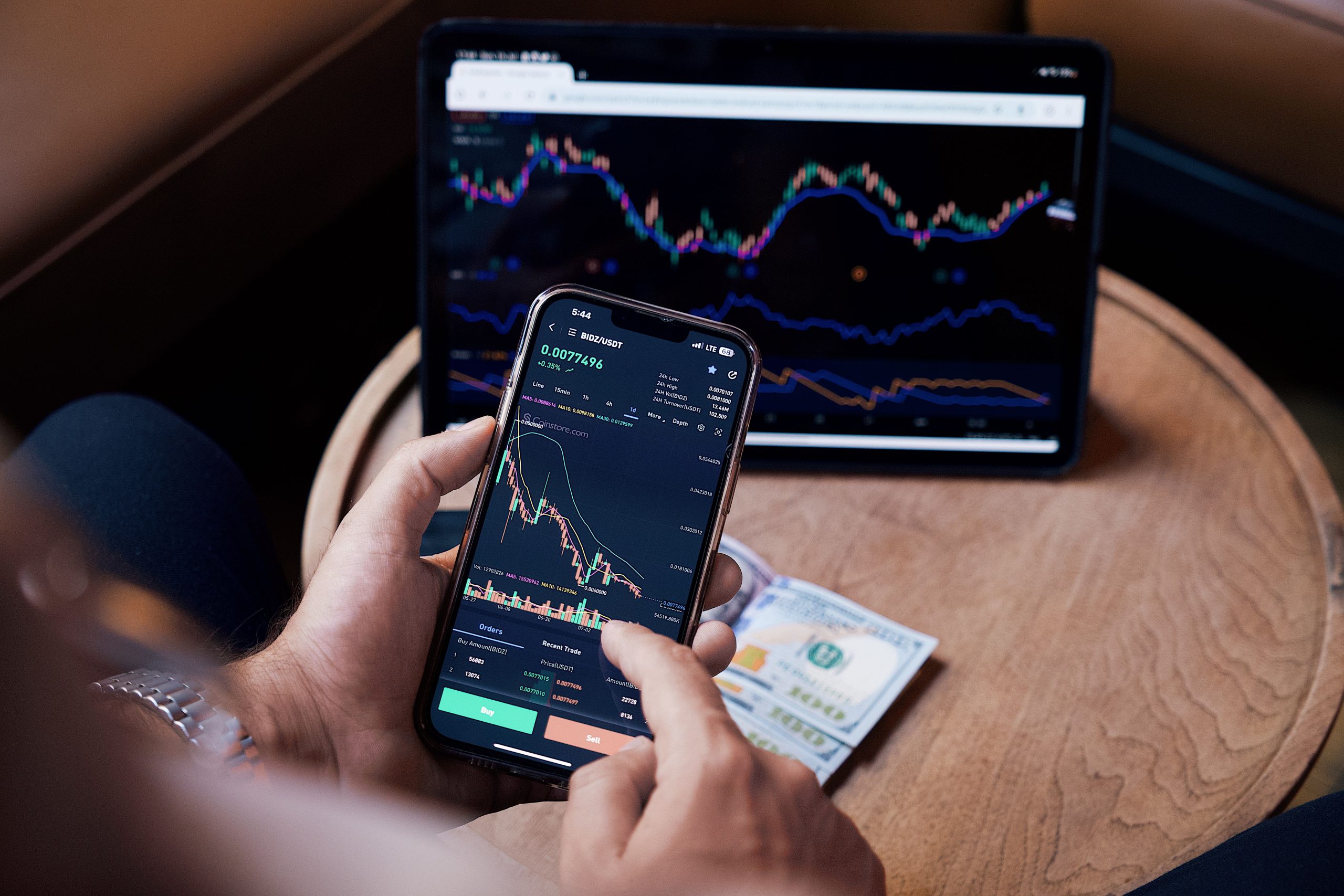Trader utilisant smartphone et tablette pour acheter actions