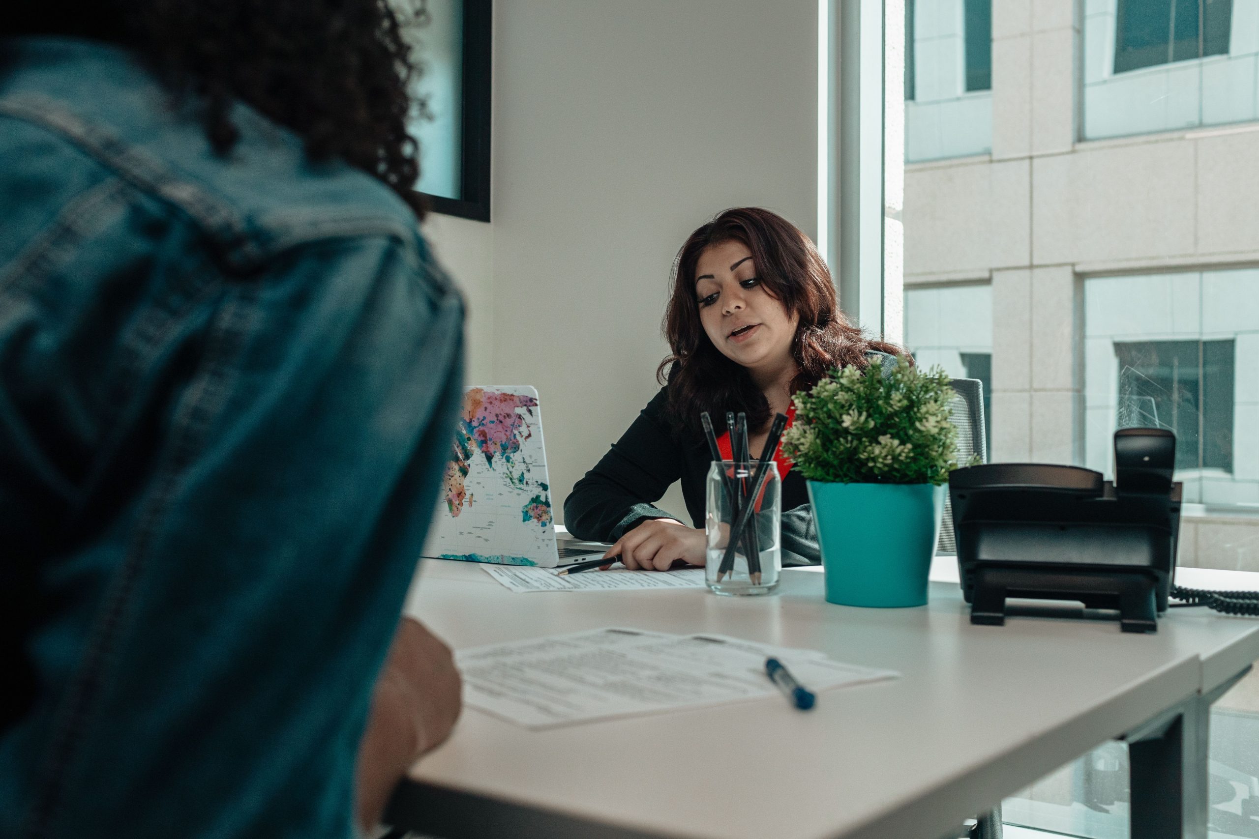 Deux collaborateurs discutent documents bureau