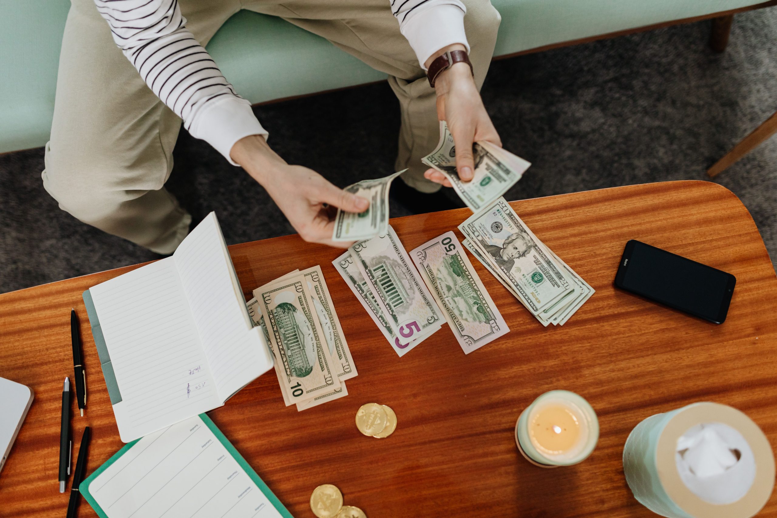 Personne comptant plusieurs billets americains a table