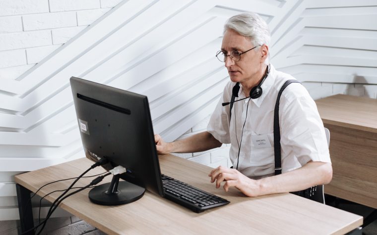 Homme senior travaillant en centre d'appels avec casque