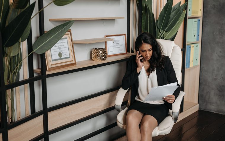 Femme professionnelle examinant documents lors appel téléphonique