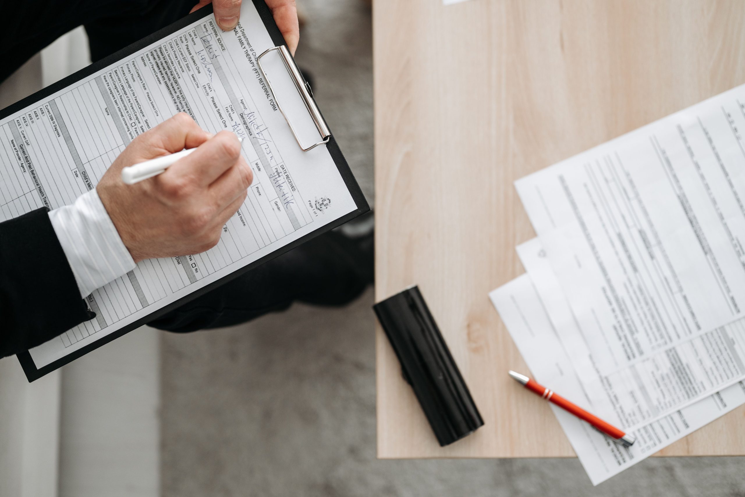 Personne remplissant formulaires sur clipboard et documents
