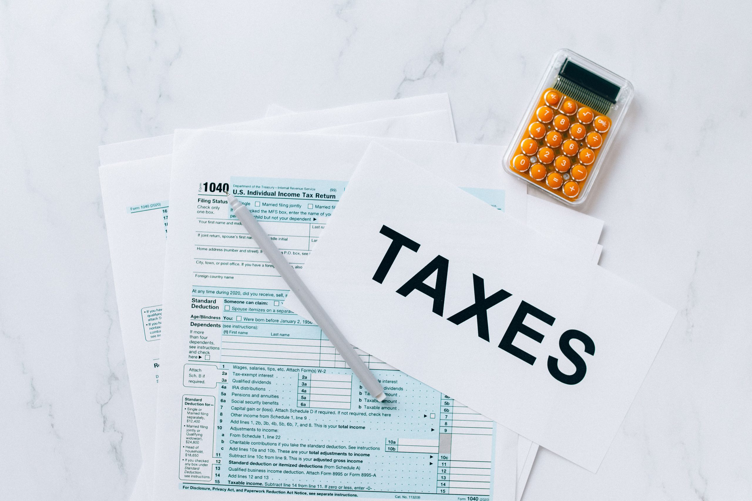 Formulaires fiscaux, calculatrice et stylo vus de dessus
